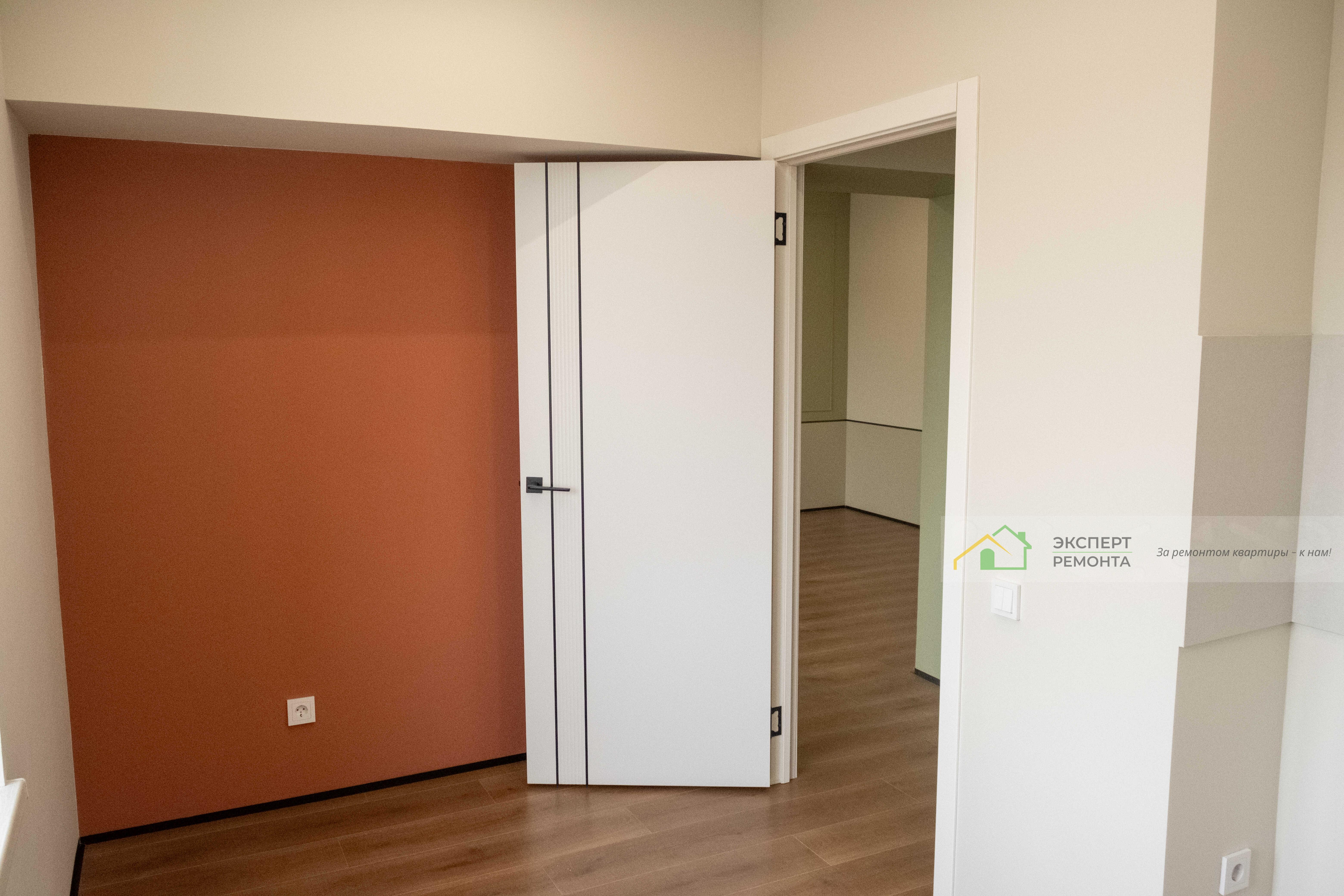 Кухня после ремонта с акцентной стеной терракотового цвета.